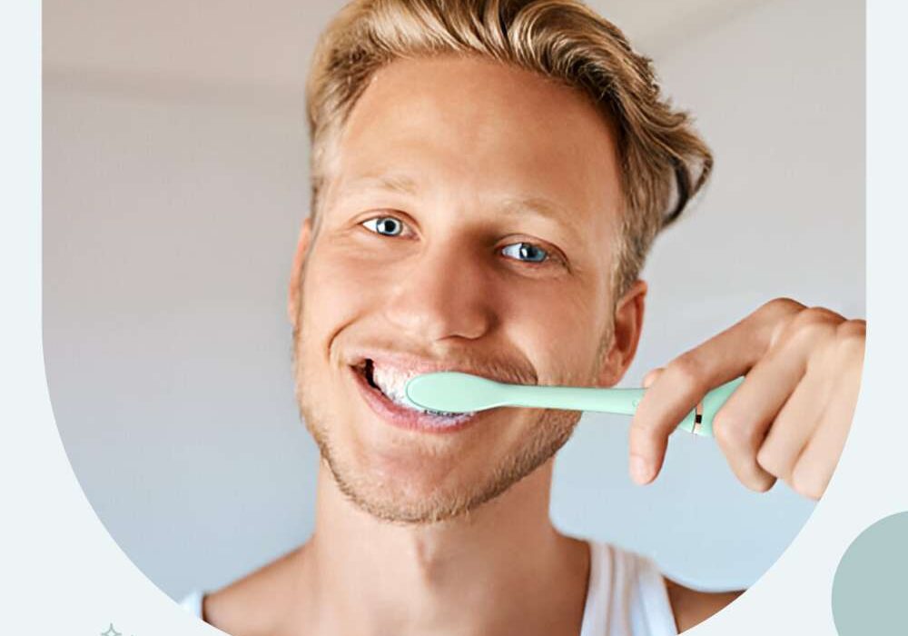 A man brushing his teeth with an electric toothbrush.